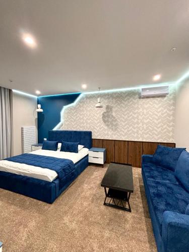 a bedroom with a blue bed and a couch at Hotel Alto in Karakol