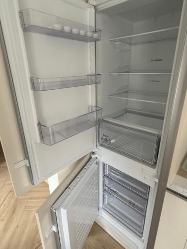 an empty refrigerator with its door open in a kitchen at Greta Apartment in Alytus