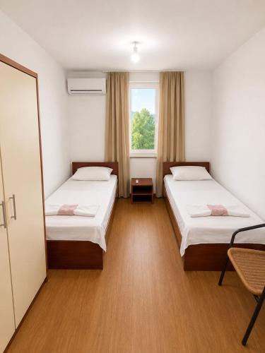 a hotel room with two beds and a window at Guest House Kekusic in Međugorje