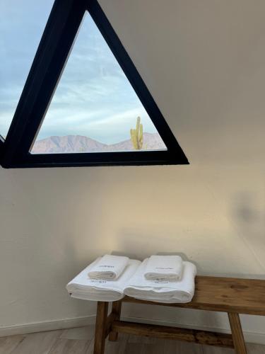 a room with a window with two towels on a bench at Glamping Astrapia - Cafayate in Cafayate