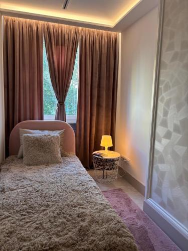 a bedroom with a large bed and a window at Apart CRYSTAL in Tomaszów Mazowiecki