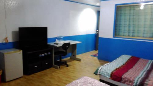 a bedroom with a desk and a bed and a table at San Ho Hotel in Taoyuan