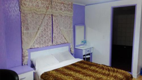 a purple bedroom with a bed and a window at San Ho Hotel in Taoyuan