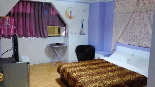 a bedroom with a bed and a tv in it at San Ho Hotel in Taoyuan