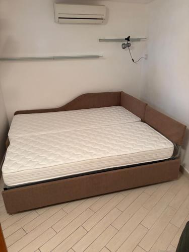 a bed in a corner of a room at SnowWhite Home in Porto Ercole