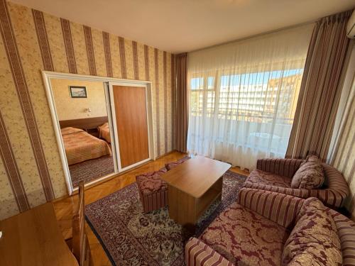 ein Wohnzimmer mit Sofa und Spiegel in der Unterkunft Hotel Olymp in Sonnenstrand