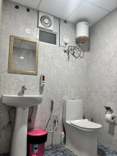 a bathroom with a sink and a toilet and a mirror at Sofitel Caravanserai 1BHK Noida, Spectrum Mall Sector 75 in Noida
