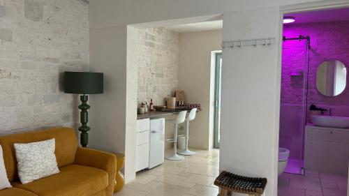 a living room with a couch and a bathroom with purple at Montesanto 60 Suite & Relax Alberobello in Alberobello