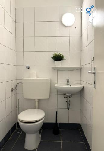 a bathroom with a toilet and a sink at BEGE APARTMENTS WorkPoint in Dorsten