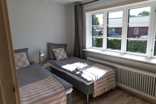 a room with two beds and a window at Billund Guest Lodge 2 in Hejnsvig