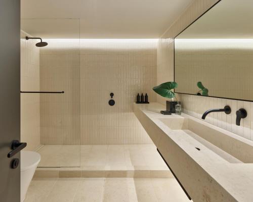 a bathroom with a shower and a toilet and a sink at The Satire, Autograph Collection in Alexandria
