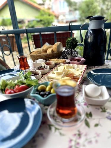a table with plates of food and a jug of tea at Mimosa House Ayvalık in Ayvalık