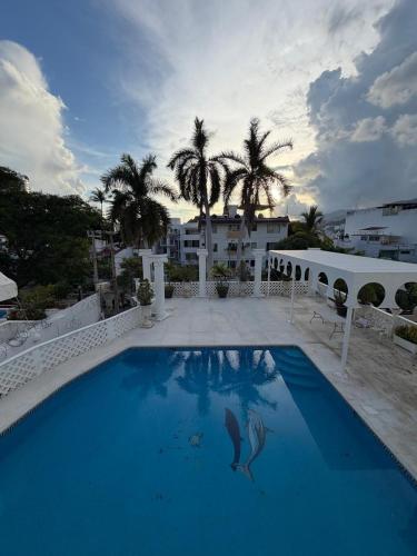 a swimming pool with a dolphin in the water at Casa Arabesca in Acapulco