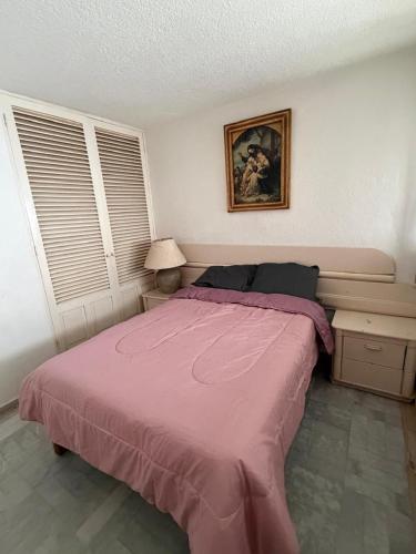 a bedroom with a bed with a pink blanket at Casa Arabesca in Acapulco