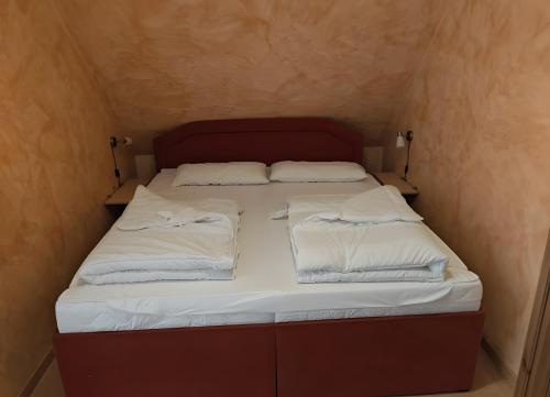 a bed in a small room with white sheets and pillows at Fewo Steuerboard in Röbel