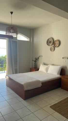 a bedroom with a large bed and a window at Venus Studios in Vlachata