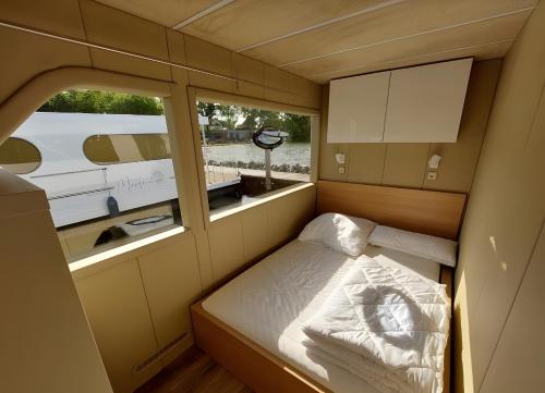 a small room with a bed and a window at Hausboot Emma Blue in Röbel