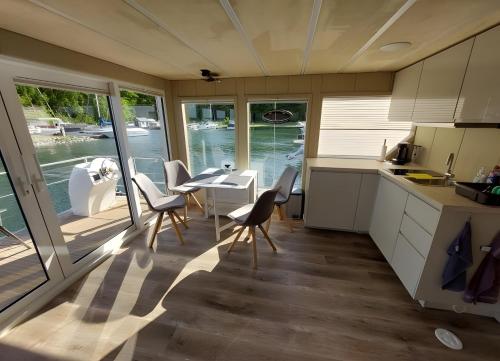 a kitchen and dining room with a table and chairs at Hausboot Emma Blue in Röbel