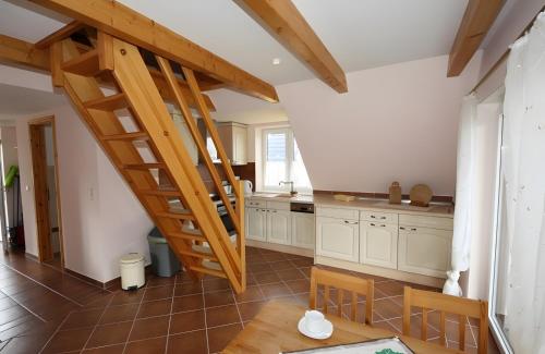 a kitchen with a wooden staircase in a house at Haus u8 in Röbel