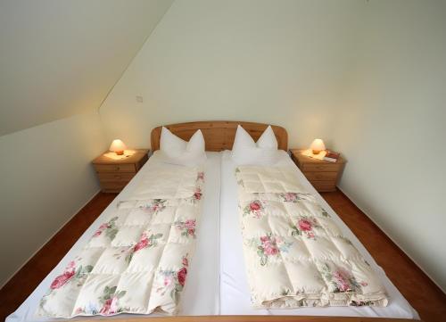two beds in a small room with two lamps at Haus u8 in Röbel