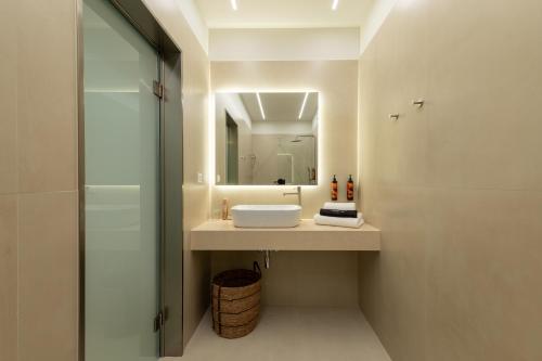 a bathroom with a sink and a mirror at IONE Suites in Preveza