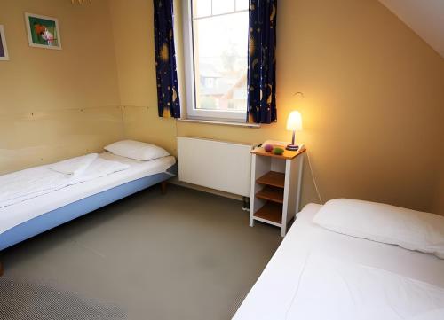 a small room with two beds and a window at Haus 12 in Röbel
