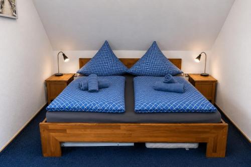 a bedroom with a bed with blue sheets and blue pillows at Haus Königsfeld in Hage