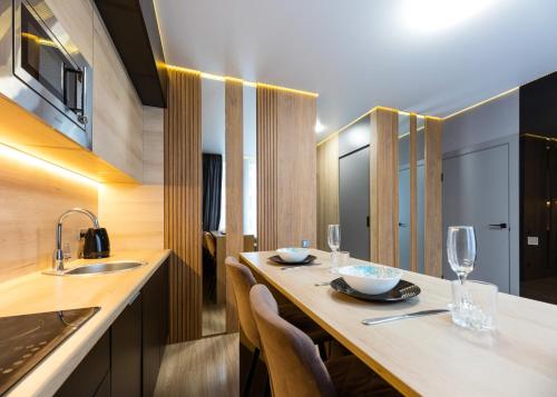 a kitchen with a long table with chairs and glasses at Fayna Town Comfort #2 in Kyiv