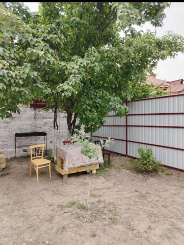 a patio with a table and a chair under a tree at good house in Quba