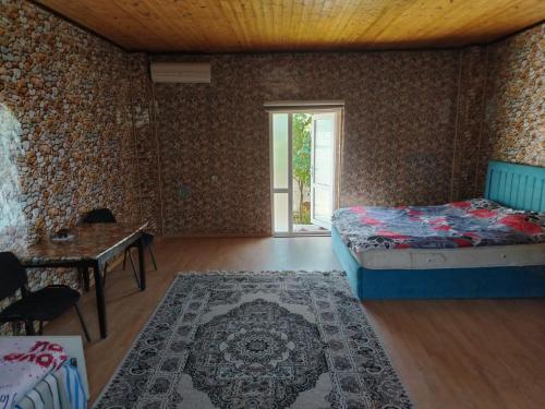 a bedroom with a bed and a table and a window at good house in Quba