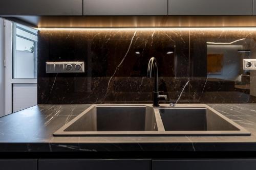 a kitchen sink with a faucet on a counter at Aeliah in Anavyssos