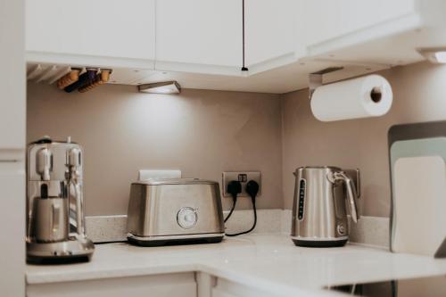 a kitchen counter with two toasters and a toaster at Saturn Studio by Navie Stays in Poole