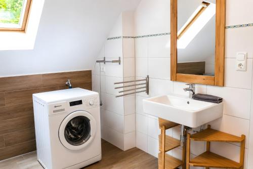 a bathroom with a washing machine and a sink at Haus Königsfeld in Hage