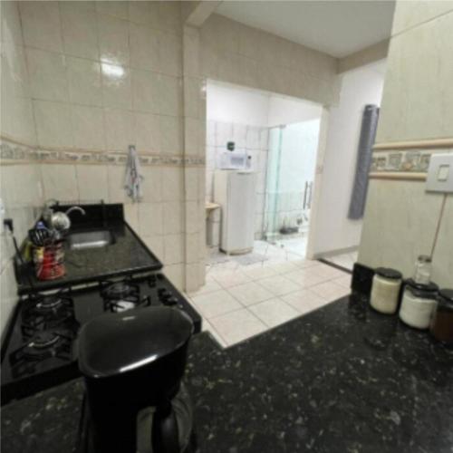 a kitchen with a stove and a sink and a refrigerator at Executivo Central 102 in Ipatinga