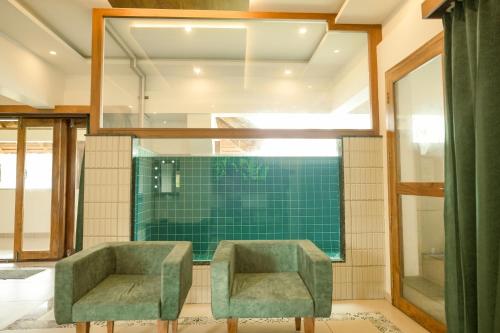two green chairs in a bathroom with a window at 36 Palms- Sun and Sand in Cochin