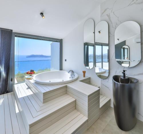 a bathroom with a tub and a large window at Villa Sky Line - Private Pool - Panoramic Sea View in Kaş