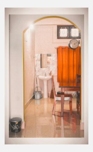 a room with a table and a chair and a sink at Mini Emphum 2BHK Apartment in Namsai