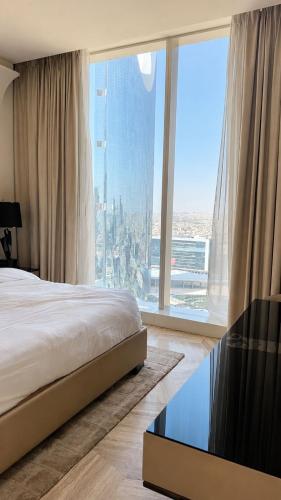 a bedroom with a bed and a large window at برج داماك الرياض in Riyadh