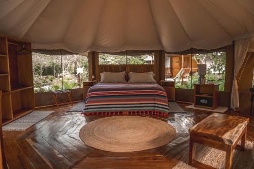 a bedroom with a bed in a tent at Destino Mío Mayan Jungle Retreat in Tekit