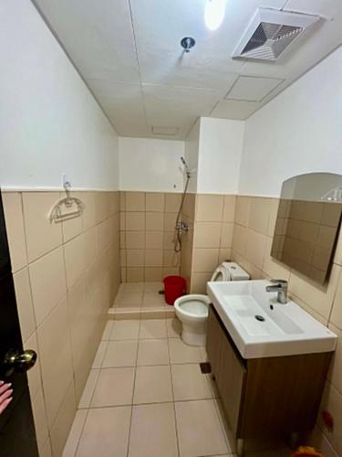 a bathroom with a toilet and a sink at D' Cozy Pines Suites in Baguio