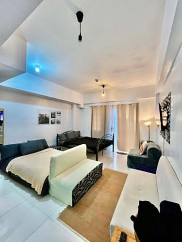 a bedroom with a bed and a living room at D' Cozy Pines Suites in Baguio