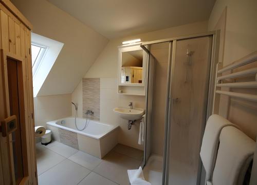 a bathroom with a shower and a tub and a sink at Roter Blitz 2 k108 in Röbel