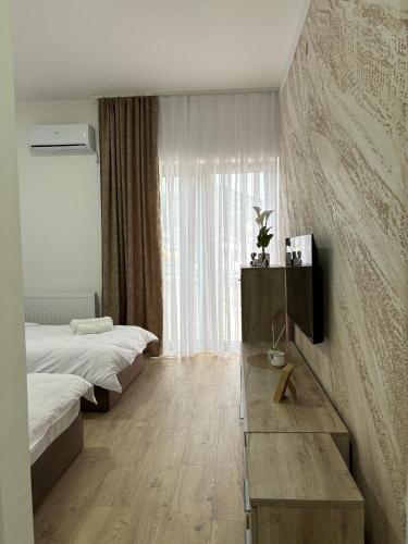 a bedroom with two beds and a table and a window at Prenoćište Lovac in Prijepolje