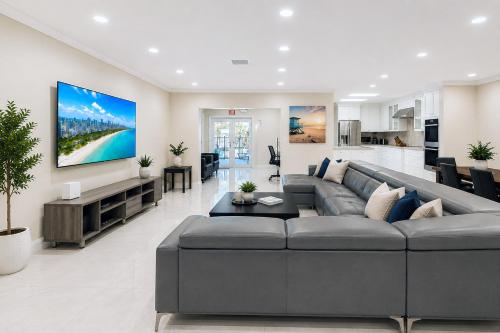 a living room with a large couch and a tv at Premium Luxury 5BR Villa near Hollywood Beach in Hollywood