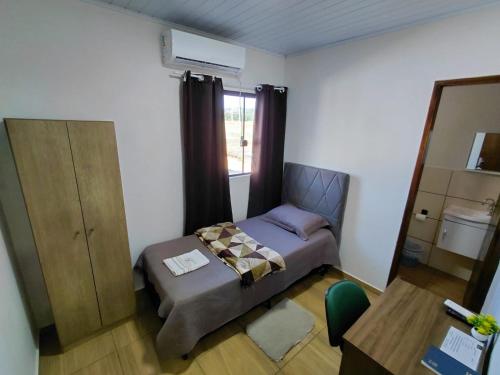 a small bedroom with a bed and a mirror at Kurten Hotelaria in Cândido de Abreu