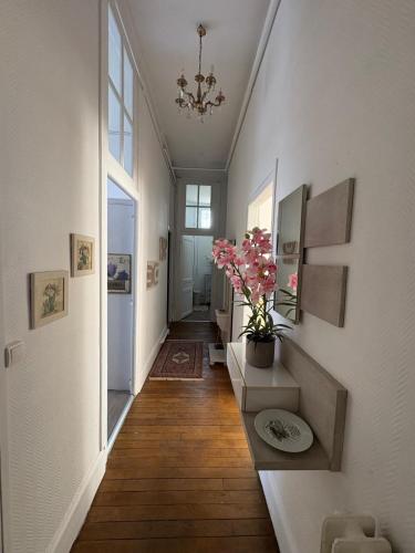 a hallway with white walls and wooden floors and a plant at La belle époque ardennaise in Sedan