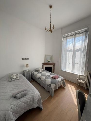 a bedroom with two beds and a window at La belle époque ardennaise in Sedan
