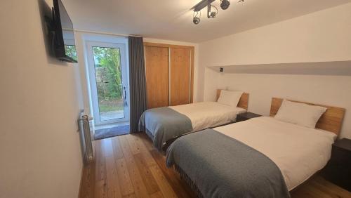 a hotel room with two beds and a window at Fernandes House in Paredes de Coura