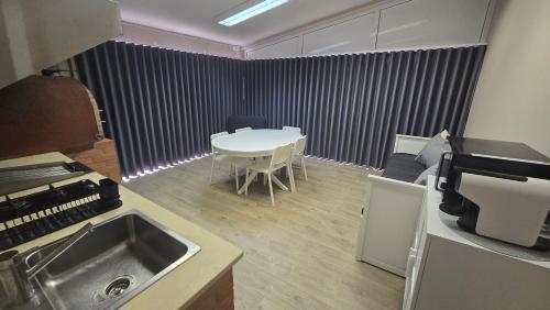 a kitchen with a sink and a table and a table and chairs at Fernandes House in Paredes de Coura