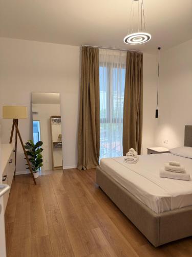 a bedroom with a bed and a large window at Foel Apartament in Tirana